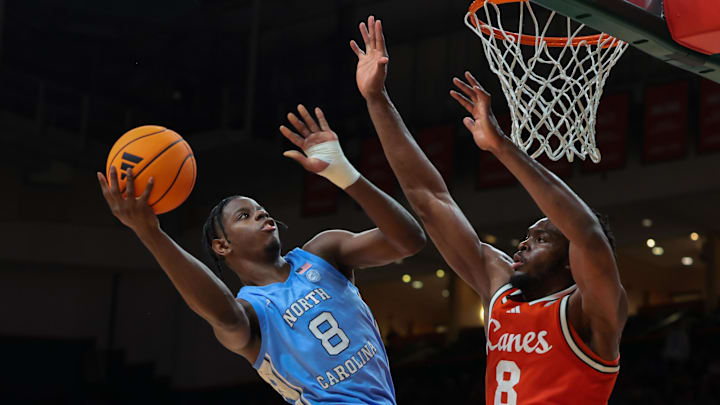 Feb 10, 2026; Coral Gables, Florida, USA; North Carolina Tar Heels forward Caleb Wilson (8) drives to the basket against Miami Hurricanes center Ernest Udeh Jr. (8) during the second half at Watsco Center. Mandatory Credit: Sam Navarro-Imagn Images
