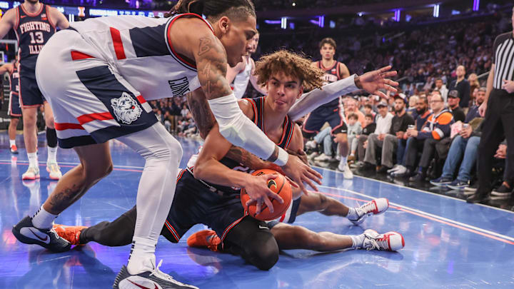 Nov 28, 2025; New York, New York, USA;  UConn Huskies guard Solo Ball (1) and Illinois Fighting Illini guard Keaton Wagler (23) fight for the ball in the second half at Madison Square Garden. Mandatory Credit: Wendell Cruz-Imagn Images