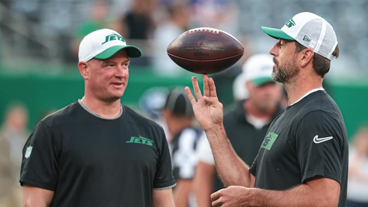 Aug 24, 2024; East Rutherford, New Jersey, USA; New York Jets quarterback Aaron Rodgers (left) spins the ball in front of offensive coordinator Nathaniel Hackett before the game against the New York Giants at MetLife Stadium. Mandatory Credit: Vincent Carchietta-Imagn Images