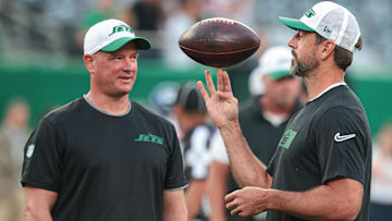 Aug 24, 2024; East Rutherford, New Jersey, USA; New York Jets quarterback Aaron Rodgers (left) spins the ball in front of offensive coordinator Nathaniel Hackett before the game against the New York Giants at MetLife Stadium. Mandatory Credit: Vincent Carchietta-Imagn Images