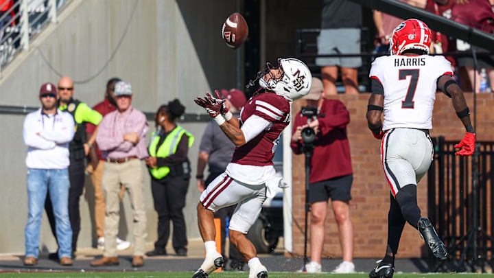 Nov 8, 2025; Starkville, Mississippi, USA; Mississippi State Bulldogs wide receiver Brenen Thompson (0) catches the ball against Georgia Bulldogs tight end Lawson Luckie (7) during the second half at Davis Wade Stadium at Scott Field. Mandatory Credit: Wesley Hale-Imagn Images