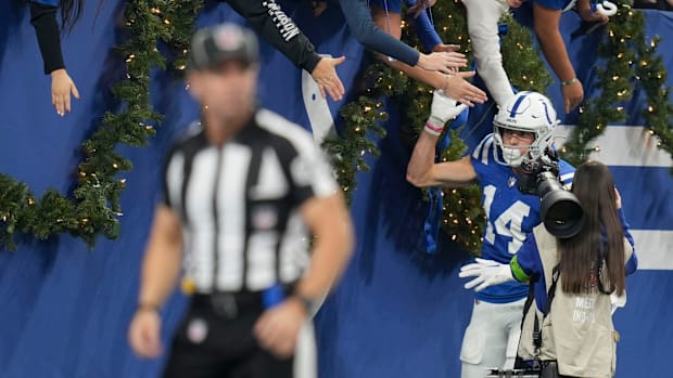 Colts wide receiver Alec Pierce (blue jersey; white helmet) celebrates after a receiving touchdown with fans. 