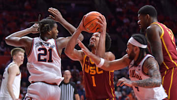 Jan 11, 2025; Champaign, Illinois, USA;  USC Trojans guard Desmond Claude (1) drives to the basket b between Illinois Fighting Illini forward Morez Johnson Jr. (21) and  Kylan Boswell (4) during the second half at State Farm Center. Mandatory Credit: Ron Johnson-Imagn Images