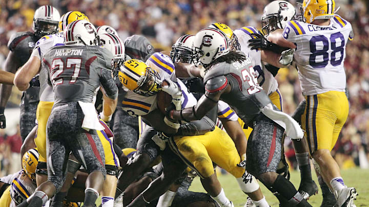 October 13, 2012; Baton Rouge, LA, USA; LSU Tigers running back Jeremy Hill (33) is tackled by South Carolina Gamecocks safety D.J. Swearinger (36) during the second half at Tiger Stadium. LSU defeated South Carolina 23-21. Mandatory Credit: Crystal LoGiudice-Imagn Images