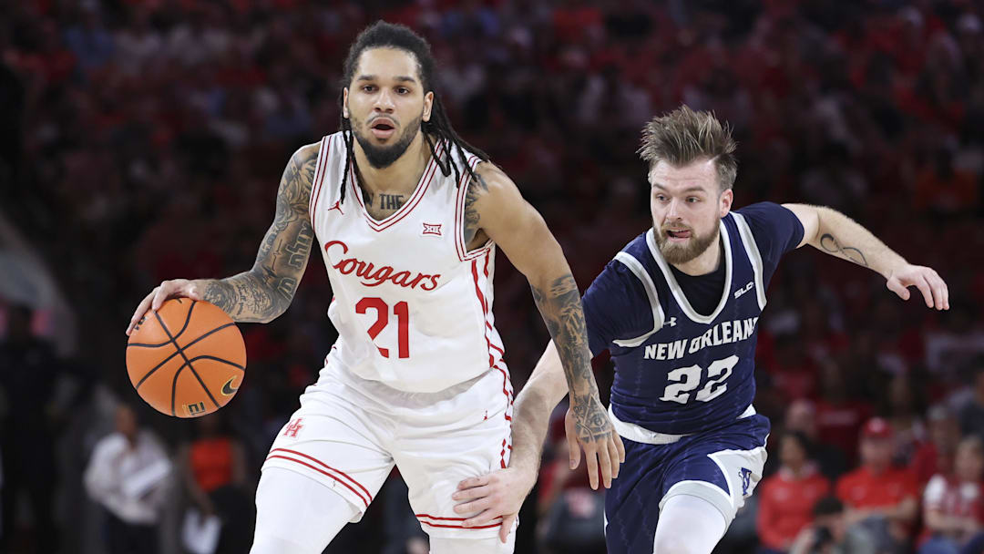 Dec 13, 2025; Houston, Texas, USA; Houston Cougars guard Emanuel Sharp (21) dribbles the ball as New Orleans Privateers guard Coleton Benson (22) defends during the first half at Fertitta Center. Mandatory Credit: Troy Taormina-Imagn Images