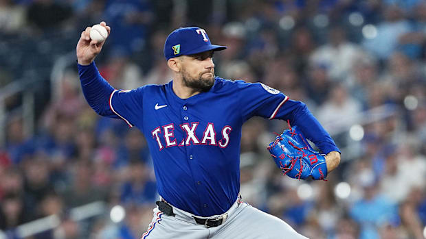 Texas Rangers pitcher Nathan Eovaldi (17) throws a pitch in a blue uniform and a blue hat