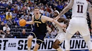 Mar 22, 2025; Denver, CO, USA; Michigan Wolverines center Danny Wolf (1) dribbles the ball past Texas A&M Aggies guard Manny Obaseki (35) during the first half in the second round of the NCAA Tournament  at Ball Arena. Mandatory Credit: Isaiah J. Downing-Imagn Images