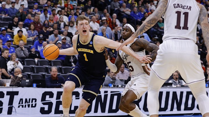Mar 22, 2025; Denver, CO, USA; Michigan Wolverines center Danny Wolf (1) dribbles the ball past Texas A&M Aggies guard Manny Obaseki (35) during the first half in the second round of the NCAA Tournament  at Ball Arena. Mandatory Credit: Isaiah J. Downing-Imagn Images