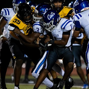 Meridian’s Martrevious Greer (1-1) runs into a host of Starkville Yellowjacket defenders on Friday, Sept. 13 in Starkville, Miss.