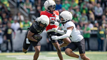Combat Ducks running back Noah Whittington, left, breaks past Fighting Ducks defensive back Jahlil Florence and defensive back Aaron Flowers as the Fighting Ducks face off against Mighty Oregon in the Oregon Ducks spring game on April 26, 2025, at Autzen Stadium in Eugene.