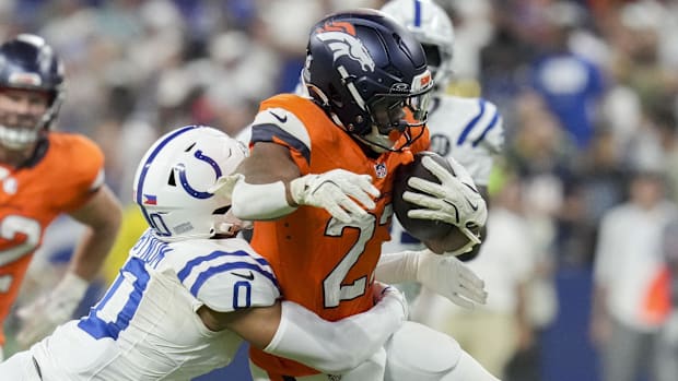 Indianapolis Colts safety Cam Bynum (0) tackles Denver Broncos running back J.K. Dobbins (27) at Lucas Oil Stadium. 