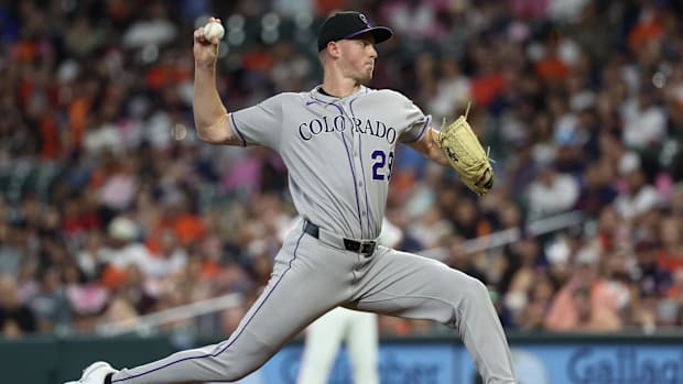 Gordon getting ready to release a white baseball off of the dirt mound in a solid grey uniform with black letterin
