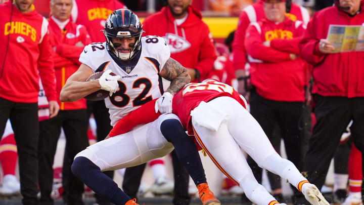 Jan 1, 2023; Kansas City, Missouri, USA; Denver Broncos tight end Eric Saubert (82) is tackled by Kansas City Chiefs safety Juan Thornhill (22) during the second half at GEHA Field at Arrowhead Stadium. Mandatory Credit: Jay Biggerstaff-USA TODAY Sports