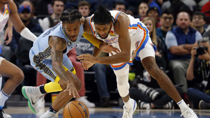 Dec 7, 2022; Memphis, Tennessee, USA; Memphis Grizzlies guard Ja Morant (12) and Oklahoma City Thunder guard Isaiah Joe (11) battle for a loose ball