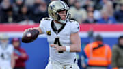 Dec 8, 2024; East Rutherford, New Jersey, USA; New Orleans Saints quarterback Derek Carr (4) drops back to pass against the New York Giants during the first quarter at MetLife Stadium. Mandatory Credit: Brad Penner-Imagn Images