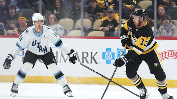 Dec 14, 2025; Pittsburgh, Pennsylvania, USA;  Pittsburgh Penguins right wing Kevin Hayes (13) moves the puck against Utah Mammoth right wing Dylan Guenther (11) during the second period t PPG Paints Arena. Mandatory Credit: Charles LeClaire-Imagn Images