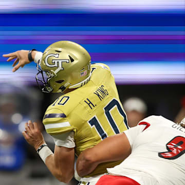 Sep 1, 2023; Atlanta, Georgia, USA; Georgia Tech Yellow Jackets quarterback Haynes King (10) is hit by Louisville Cardinals defensive lineman Ashton Gillotte (9) while throwing an interception in the first quarter at Mercedes-Benz Stadium. Mandatory Credit: Brett Davis-Imagn Images