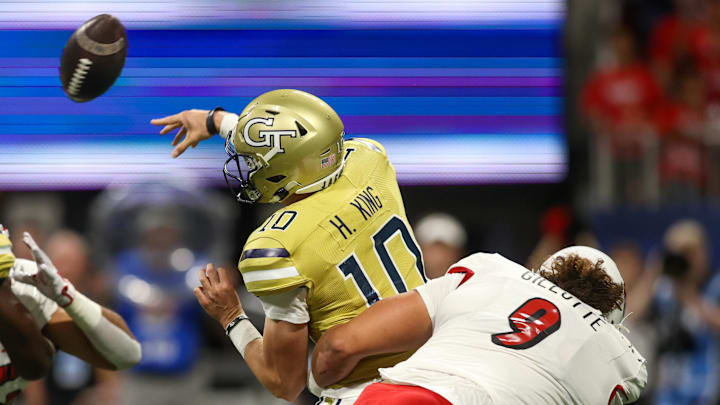 Sep 1, 2023; Atlanta, Georgia, USA; Georgia Tech Yellow Jackets quarterback Haynes King (10) is hit by Louisville Cardinals defensive lineman Ashton Gillotte (9) while throwing an interception in the first quarter at Mercedes-Benz Stadium. Mandatory Credit: Brett Davis-Imagn Images