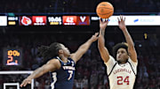 Jan 18, 2025; Louisville, Kentucky, USA; Louisville Cardinals guard Chucky Hepburn (24) shoots against Virginia Cavaliers guard Dai Dai Ames (7) during the second half at KFC Yum! Center. Louisville defeated Virginia 81-67. Mandatory Credit: Jamie Rhodes-Imagn Images