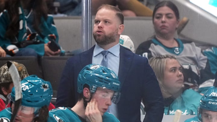 Nov 8, 2025; San Jose, California, USA; San Jose Sharks head coach Ryan Warsofsky (center) stands behind the bench during the third period against the Florida Panthers at SAP Center at San Jose. Mandatory Credit: Darren Yamashita-Imagn Images