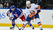 Apr 13, 2024; New York, New York, USA;  New York Islanders center Mathew Barzal (13) controls the puck defended by New York Rangers center Barclay Goodrow (21) during the third period at Madison Square Garden.