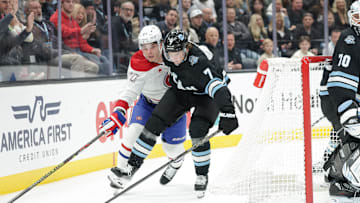 Jan 14, 2025; Salt Lake City, Utah, USA;  Utah Hockey Club defenseman Michael Kesselring (7) and Montreal Canadiens left wing Juraj Slafkovsky (20) fight for the puck during the third period at Delta Center. Mandatory Credit: Chris Nicoll-Imagn Images