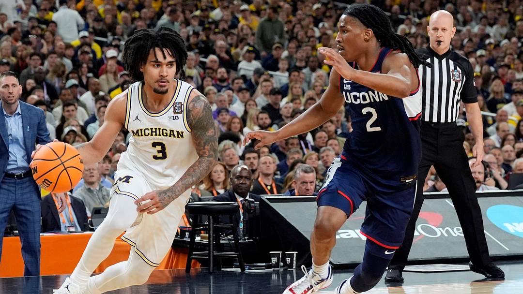 Michigan guard Elliot Cadeau dribbles the ball around Connecticut guard Silas Demary Jr. during the first half of the NCAA national championship game at Lucas Oil Stadium in Indianapolis on Monday, April 6, 2026.