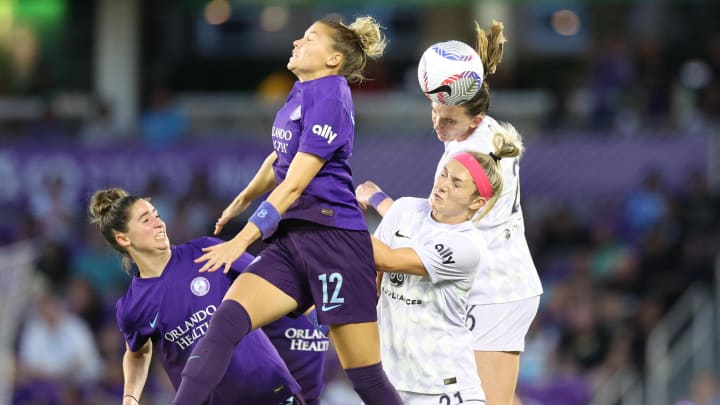 May 5, 2024; Orlando, Florida, USA;  -Racing Louisville FC forward Parker Goins (21) heads the ball against Orlando Pride defender Carrie Lawrence (12) during the second half at Inter&Co Stadium. Mandatory Credit: Nathan Ray Seebeck-USA TODAY Sports