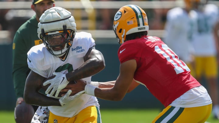 Green Bay Packers running back Josh Jacobs (8) receives a handoff from quarterback Jordan Love at training camp on Wednesday.