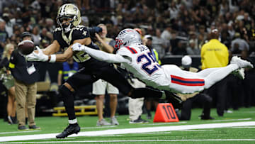 New Orleans Saints WR Chris Olave (12) tries to catch a ball while being defended by New England Patriots CB Marcus Jones (25)