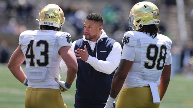 Marcus Freeman speaks to two Notre Dame players during the spring game in 2024.