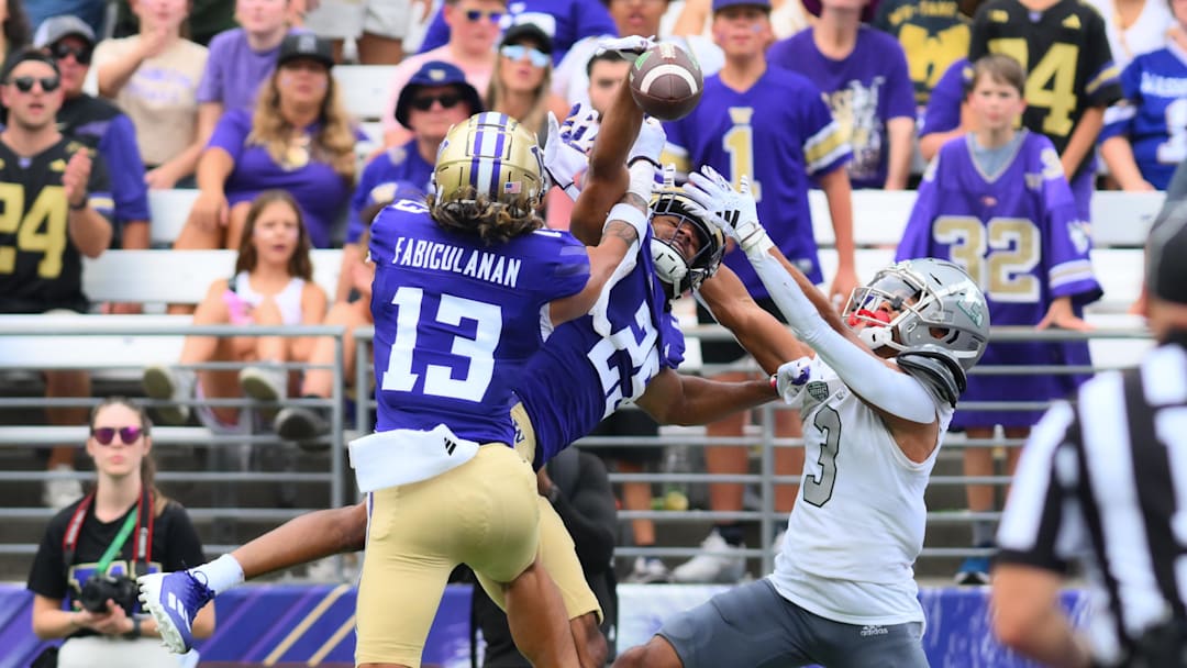 Sep 7, 2024; Seattle, Washington, USA; Washington Huskies cornerback Elijah Jackson (25) and safety Kamren Fabiculanan (13) break up a pass intended for Eastern Michigan Eagles wide receiver Terry Lockett Jr. (3) during the second half at Alaska Airlines Field at Husky Stadium. Mandatory Credit: Steven Bisig-Imagn Images