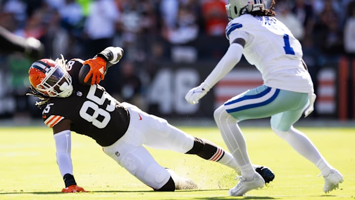 Sep 8, 2024; Cleveland, Ohio, USA; Cleveland Browns tight end David Njoku (85) falls while running the ball under coverage by Dallas Cowboys cornerback Trevon Diggs (7) during the first quarter at Huntington Bank Field. Mandatory Credit: Scott Galvin-Imagn Images