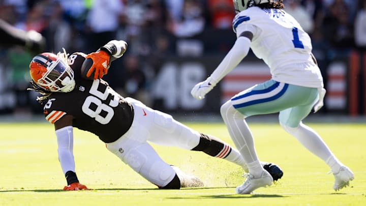 Sep 8, 2024; Cleveland, Ohio, USA; Cleveland Browns tight end David Njoku (85) falls while running the ball under coverage by Dallas Cowboys cornerback Trevon Diggs (7) during the first quarter at Huntington Bank Field. Mandatory Credit: Scott Galvin-Imagn Images