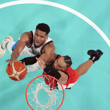 Jul 27, 2024; Villeneuve-d'Ascq, France; Greece small forward Giannis Antetokounmpo (34) reaches for the ball against Canada small forward Dillon Brooks (24) in the second half during the Paris 2024 Olympic Summer Games at Stade Pierre-Mauroy. Mandatory Credit: John David Mercer-USA TODAY Sports