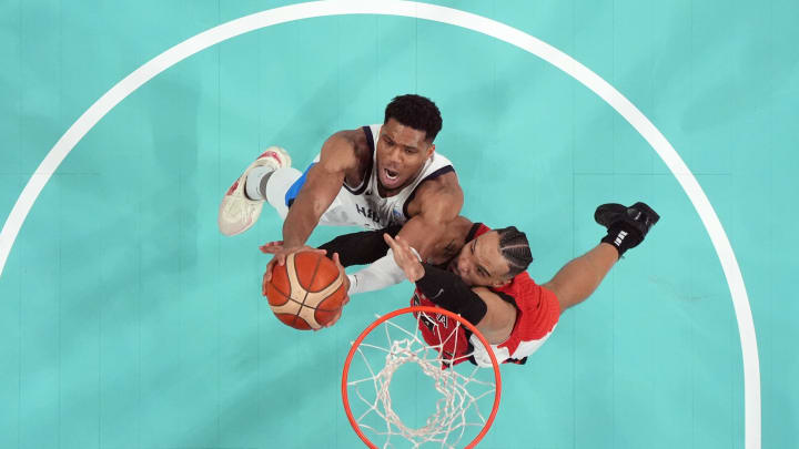 Jul 27, 2024; Villeneuve-d'Ascq, France; Greece small forward Giannis Antetokounmpo (34) reaches for the ball against Canada small forward Dillon Brooks (24) in the second half during the Paris 2024 Olympic Summer Games at Stade Pierre-Mauroy. Mandatory Credit: John David Mercer-USA TODAY Sports