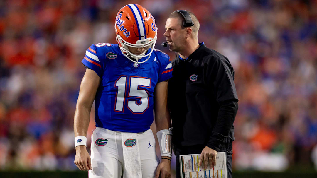 Florida Gators head coach Billy Napier and Florida Gators quarterback Graham Mertz (15) talk during a timeout in their game against Georgia.