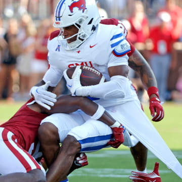 Oklahoma's Danny Stutsman (28) and Gentry Williams (9) tackle SMU's Keldric Luster (6) in the first half against the Oklahoma Sooners and the Mustangs at the Gaylord Family Oklahoma Memorial Stadium in Norman, Okla., on Sept. 9, 2023.