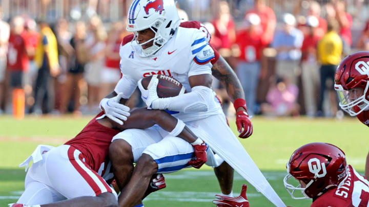 Oklahoma's Danny Stutsman (28) and Gentry Williams (9) tackle SMU's Keldric Luster (6) in the first half against the Oklahoma Sooners and the Mustangs at the Gaylord Family Oklahoma Memorial Stadium in Norman, Okla., on Sept. 9, 2023.