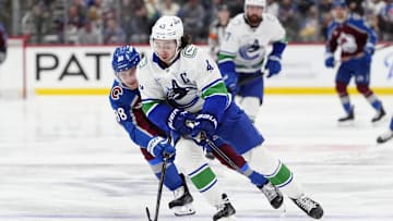 Dec 2, 2025; Denver, Colorado, USA; Colorado Avalanche center Martin Necas (88) defends on Vancouver Canucks defenseman Quinn Hughes (43) during the second period at Ball Arena. Mandatory Credit: Ron Chenoy-Imagn Images
