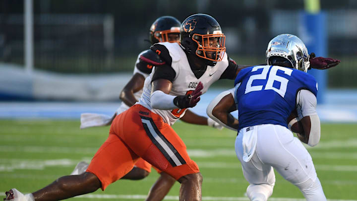 Cocoa High defensive end Javion Hilson (#9) wraps up IMG Academy running back Donovan Johnson (#26). The IMG Academy National squad hosted the Cocoa High School Tigers Friday, Sept. 6, 2024 in Bradenton.