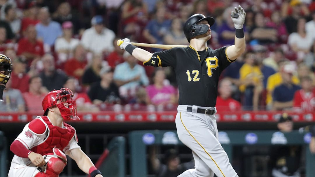 Jul 30, 2019; Cincinnati, OH, USA; Pittsburgh Pirates left fielder Corey Dickerson (12) follows through on a swing for a solo home run against the Cincinnati Reds during the seventh inning at Great American Ball Park. Mandatory Credit: David Kohl-Imagn Images