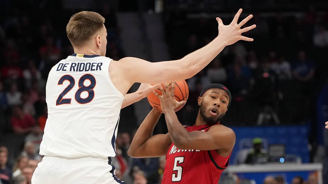 Mar 12, 2026; Charlotte, NC, USA; NC State Wolfpack guard Tre Holloman (5) with the ball as Virginia Cavaliers forward Thijs de Ridder (28) defends in the first half at Spectrum Center. Mandatory Credit: Bob Donnan-Imagn Images