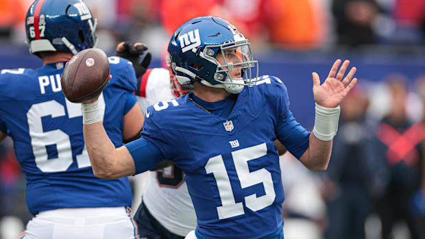 Aug 21, 2025; East Rutherford, New Jersey, USA; New York Giants quarterback Tommy DeVito (15) runs with the ball chased by Ne