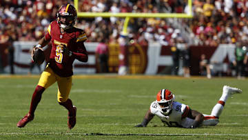 Oct 6, 2024; Landover, Maryland, USA; Washington Commanders quarterback Jayden Daniels (5) runs with the ball past Cleveland Browns defensive end Za'Darius Smith (99) during the second quarter at NorthWest Stadium. Mandatory Credit: Geoff Burke-Imagn Images