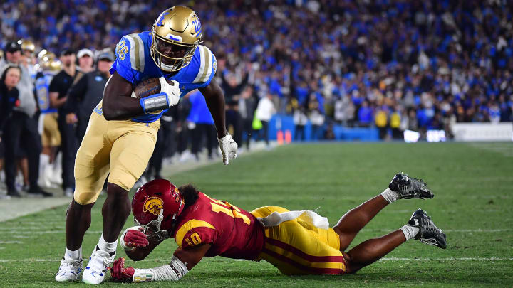 Nov 19, 2022; Pasadena, California, USA; UCLA Bruins tight end Michael Ezeike (86) runs the ball for a touchdown against Southern California Trojans linebacker Ralen Goforth (10) during the second half at the Rose Bowl.