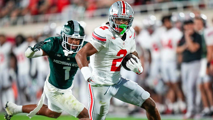 Ohio State Buckeyes wide receiver Emeka Egbuka runs the ball against Michigan State Spartans defensive back Nikai Martinez in the second half at Spartan Stadium.