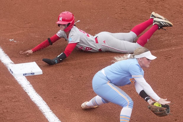 The NEBRASKA Public Service Lanceman, Jordyn Bahl (98), slips safely in the third base during a super regional NCAA game.