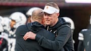 Southern California Trojans head coach Lincoln Riley and Nebraska Cornhuskers head coach Matt Rhule embrace before the game at Memorial Stadium. 