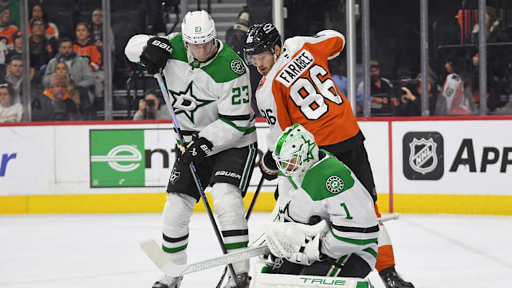 Jan 9, 2025; Philadelphia, Pennsylvania, USA; Dallas Stars goaltender Casey DeSmith (1) makes a save as defenseman Esa Lindell (23) holds back Philadelphia Flyers left wing Joel Farabee (86) during the first period at Wells Fargo Center. Mandatory Credit: Eric Hartline-Imagn Images
